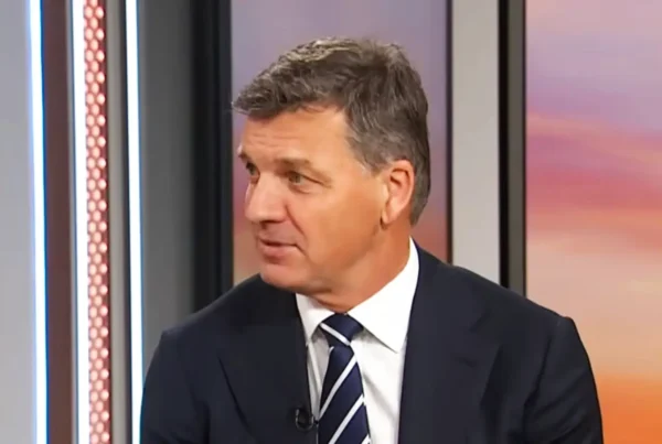 Angus Taylor gestures mid-answer during a television interview